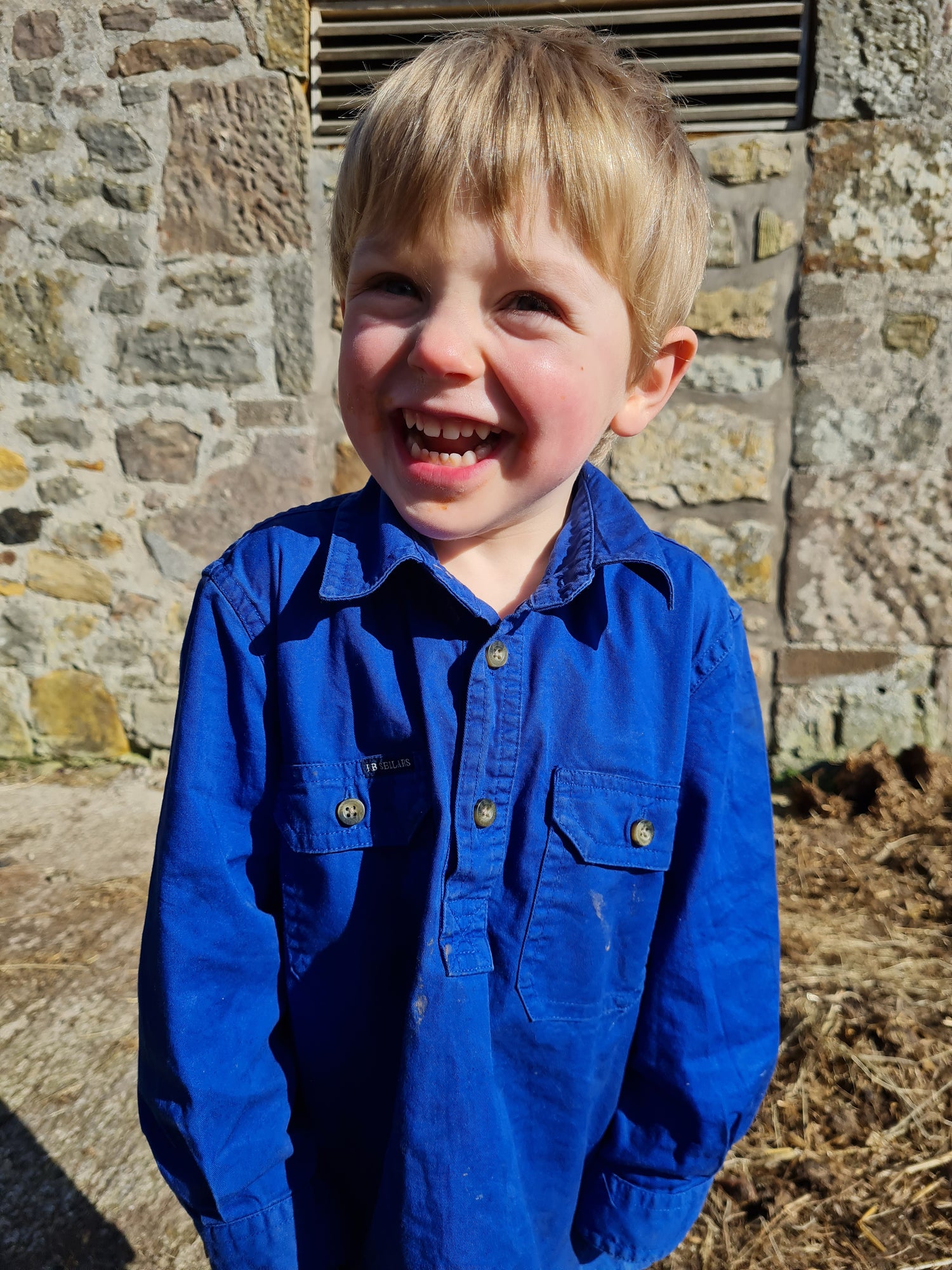 Child in a blue RB Sellars Burton Junior workshirt