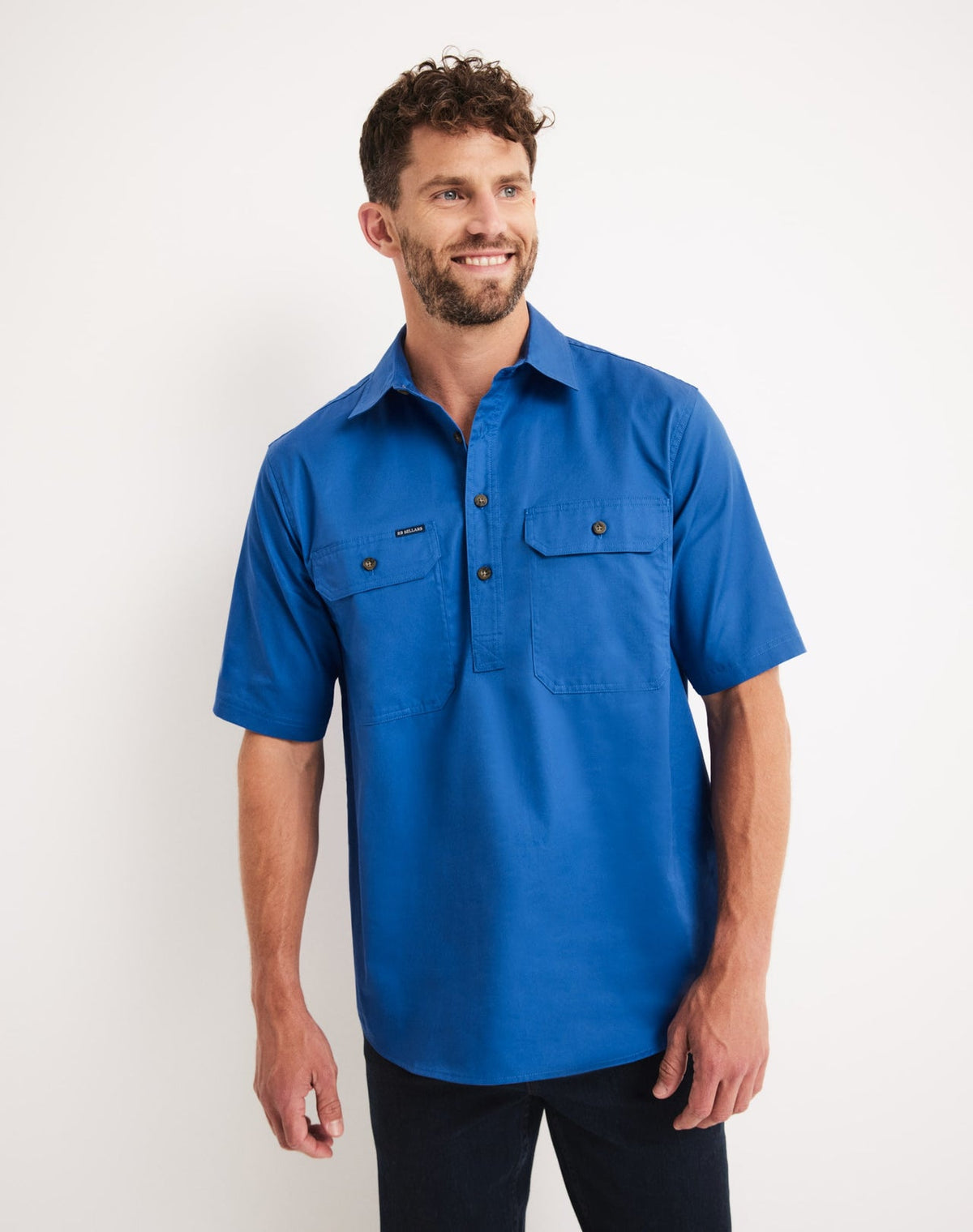 Man wearing an RB Sellars blue short-sleeve shirt against a white background