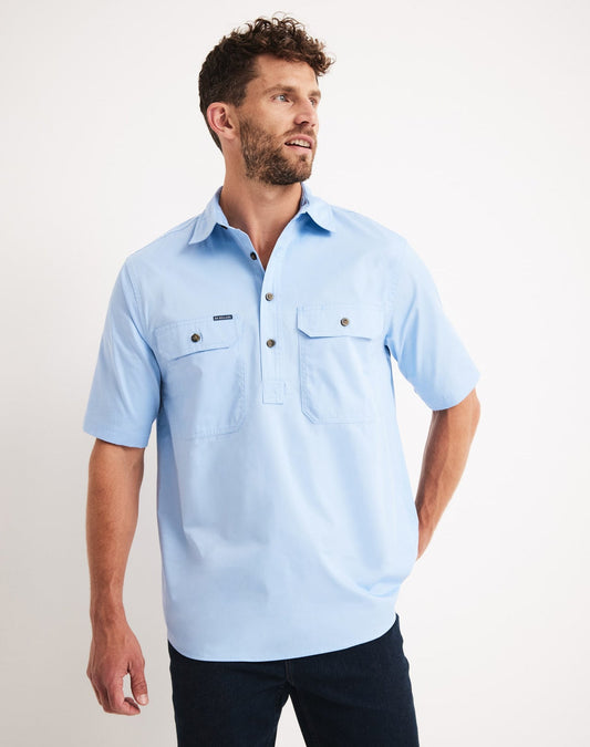 Man wearing a light blue short-sleeve RB Sellars shirt with a brand logo on a white background at Bleak Ridge Clothing