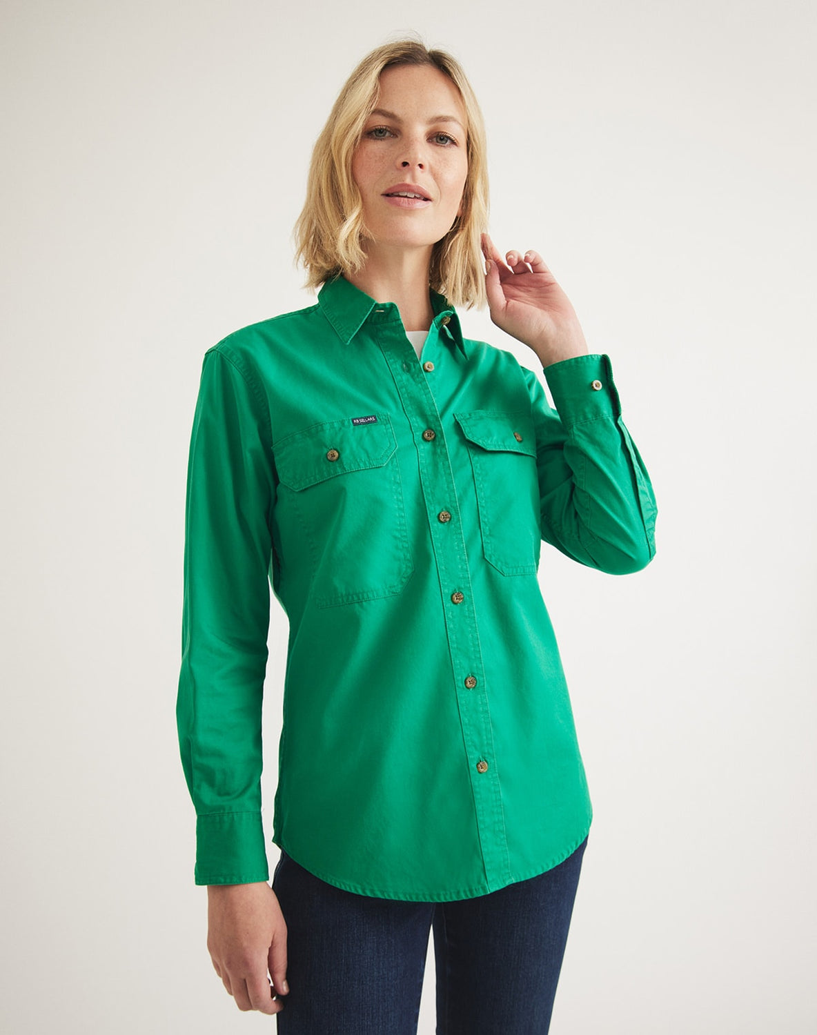 This women's green cotton shirt is breathable and has a UPF rating of 50+. The top has buttoned cuffs and pockets in green.