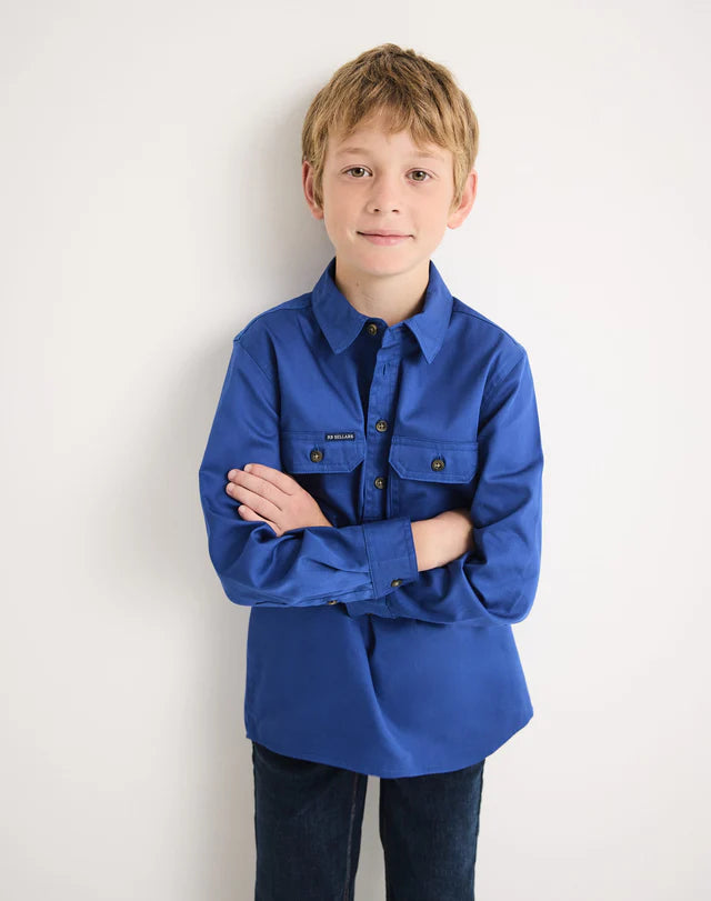 Young boy wearing a royal blue RB Sellars shirt against a white background